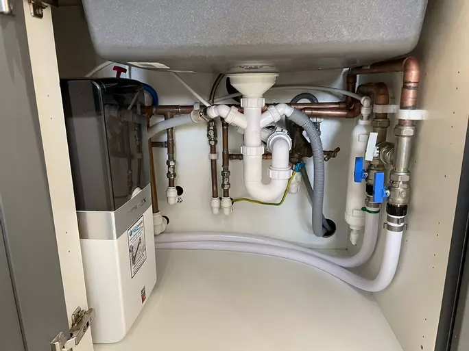 Tucking the softener into a corner cupboard, under the kitchen sink